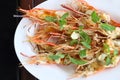 Top view, close up grilled fresh river shrimp with seafood sauce, slice garlic and mint leaves in white plate on wood table Royalty Free Stock Photo