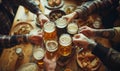 Top view Close-up of hands clinking beer mugs on wooden table with snacks in pub, capturing cheerful toast among friends. Image Royalty Free Stock Photo
