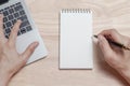 Top view and close up of man`s hands using laptop and writing in notepad. Working on project concept Royalty Free Stock Photo