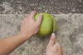 Close up man use big sharp knife to peel green fresh coconut Royalty Free Stock Photo