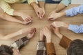Top view of the hands of a group of people sitting in a circle and holding hands. Royalty Free Stock Photo