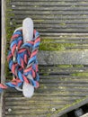 Boat rope tied on pier bollard on wooden pier Royalty Free Stock Photo