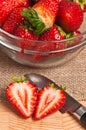 sliced, local, ripe and freshly picked strawberry, with pairing knife and a clear glass bowl of strawberries Royalty Free Stock Photo