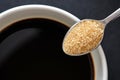 Top view, Close up of teaspoon of brown sugar, cane sugar with white cup of coffee, copy space for text Royalty Free Stock Photo