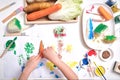 Top view close up of toddler boy child hands, kid making artwork from vegetable stamping at home, Fun art and crafts for toddlers