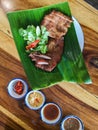 Top view Close up traditional local style food juicy yummy tasty fried roasted sliced meat pork on nature green banana leaf