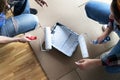 Top view. Close up of two women loading paint roller in paint tray. Preparing to paint house walls white