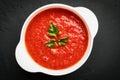 Top view close-up of a white bowl of tomato soup with parsley on a dark background Royalty Free Stock Photo