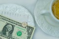 Top view close-up on white plate with American dollars bills and coins, selective focus, cup of coffee, dishes with food, lunch Royalty Free Stock Photo