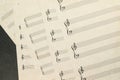 Top view closeup of aged blank music paper with staff and clefs on a grey surface Royalty Free Stock Photo