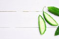 Top view closeup of bitter gourd on white wooden board background Royalty Free Stock Photo