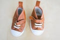 Top view closeup of a brown pair of shoes for a baby on a white surface