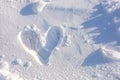 Closeup couple`s deep footprint in heart shape on snow