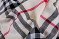 Top view closeup crumpled milky checked scarf with black, white and red strips