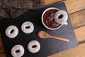 Top view closeup of doughnuts on black surface with hot chocolate drink and doughnut dipping inside Royalty Free Stock Photo