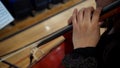 top view closeup on the hand of a hispanic woman playing cello, latin violoncellist performing a classical music piece, high angle