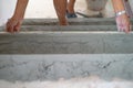 Closeup hands of worker works with trowel in plastered cement floor