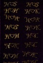 Top view closeup of initial combinations made out of gold for necklaces on a dark background Royalty Free Stock Photo