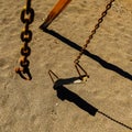 Top view closeup of the old rusty metal chains of the broken swing on the sand at the beach Royalty Free Stock Photo