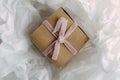 Top view and closeup of present box with pink bow on the white tissue paper