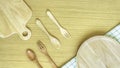 Top view closeup set of wooden cutlery utensil. Wooden fork, spoon, plate on wooden table background. Clean green and white checke