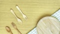 Top view closeup set of wooden cutlery utensil. Wooden fork, spoon, plate on wooden table background. Clean green and white checke