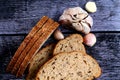 Top view closeup of a sliced loaf of brown bread and garlic cloves on a wooden table Royalty Free Stock Photo