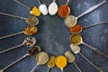 Top view closeup of the variety of spices on the vintage silver spoons on a blue background