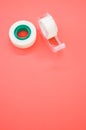 Top view closeup of a white duct tape and a tape dispenser isolated on a bright pink background Royalty Free Stock Photo