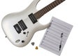 Top view of closeup of white electric guitar, two mediators, notes&tabs stuff and pen. Workspace of musician. Isolated on white