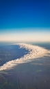 Top view of a cloud formation on the blue sky and the land and trees Royalty Free Stock Photo