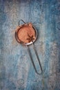 Top view of cocoa powder in silver strainer with anise star