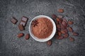 Top view of cocoa powder in white bowl with pieces of chocolate bar and cocoa beans Royalty Free Stock Photo