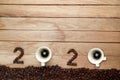 Top view of coffee beans and hot fresh coffee in a white cup with foam and text number design 2024 for Happy New Year Concept. on Royalty Free Stock Photo