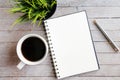 Top view of Coffee, blank notebook, pen and crop green plant o