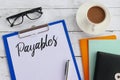 Top view of coffee,books,glasses,pen,clipboard and paper written with Payables Royalty Free Stock Photo