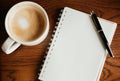 Top view. coffee cup with coffee. pen putting on blank notebook. Royalty Free Stock Photo