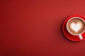 Top view of coffee cup with heart shaped latte art on side of red background with copy space Royalty Free Stock Photo