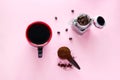 coffee cup, spoon of ground coffee beans and jar with coffee beans on a pink background Royalty Free Stock Photo