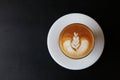 Top view of coffee latte with tulip pattern on top with dark black table background Royalty Free Stock Photo