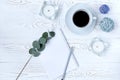 Top view of coffee mug, blank notepad, pencil, flowers and candles on white table. Flat lay Royalty Free Stock Photo