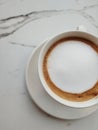 Top view coffe with silky milk foam on white marble patterned table Royalty Free Stock Photo