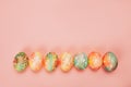 Top view of color easter eggs differen patterns. Line of eggs on yellow background Royalty Free Stock Photo