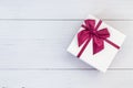 Top view color gift box with ribbon on white wooden plank