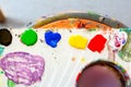 Top view of color palette with pints prepared for mixing and painting. Flat lay, Multicolored vibrant colorful art background