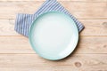 Top view on colored background empty round blue plate on tablecloth for food. Empty dish on napkin with space for your Royalty Free Stock Photo