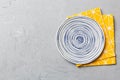 Top view on colored background empty round blue plate on tablecloth for food. Empty dish on napkin with space for your Royalty Free Stock Photo