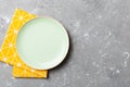 Top view on colored background empty round green plate on tablecloth for food. Empty dish on napkin with space for your Royalty Free Stock Photo
