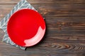 Top view on colored background empty round red plate on tablecloth for food. Empty dish on napkin with space for your Royalty Free Stock Photo