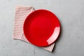 Top view on colored background empty round red plate on tablecloth for food. Empty dish on napkin with space for your Royalty Free Stock Photo